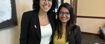 Two women smiling in a conference room