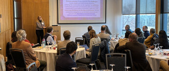 A group of people sitting at tables in a meeting