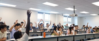 Students raising their hands in a classroom