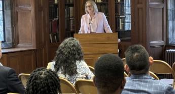 Karin Fischer speaking at a podium to a crowd