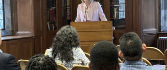 Karin Fischer speaking at a podium to a crowd