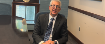 Scott Koerwer sitting in a chair in a conference room