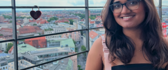 A young woman standing in front of a window in a tower