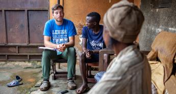 A student interviews a resident of Bududa, Uganda