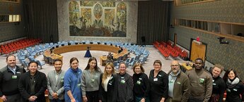 A group of people posing for a photo at the United Nations headquarters