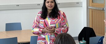 Vinita Desai talking to a group of people who are off-camera