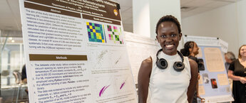 A young woman standing in front of an information display