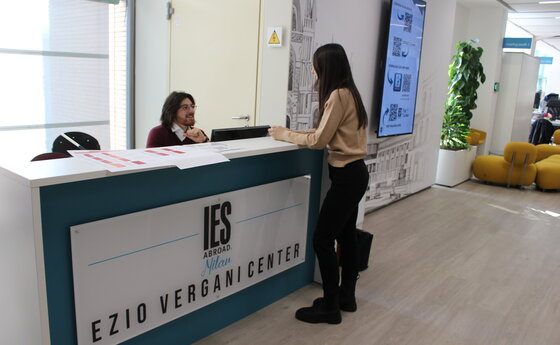 A woman speaking to a man seated at an IES Abroad desk