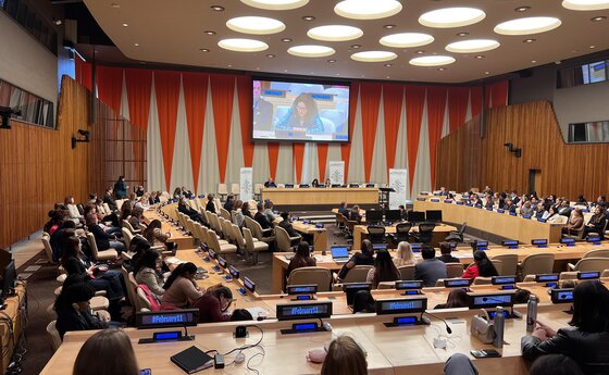 A group of people listening to a speaker at the United Nations headquarters