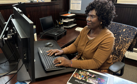 Asenath Asha Lutabingwa working at her computer