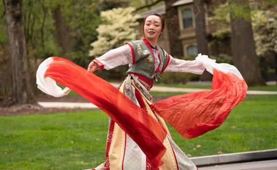 A young woman dancing on a college campus