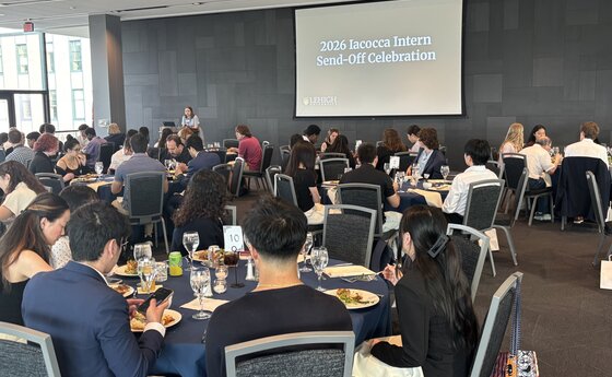 A group of people eating dinner at tables in a large conference room