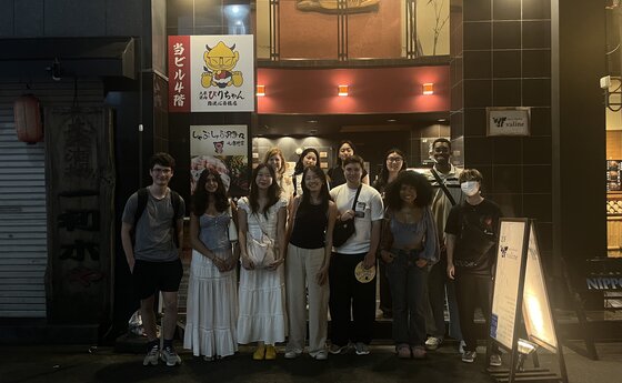 A group of students standing outside a restaurant