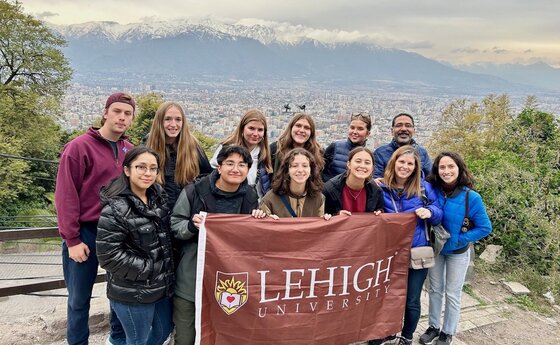Lehigh students holding a university banner in front of a view of Chile