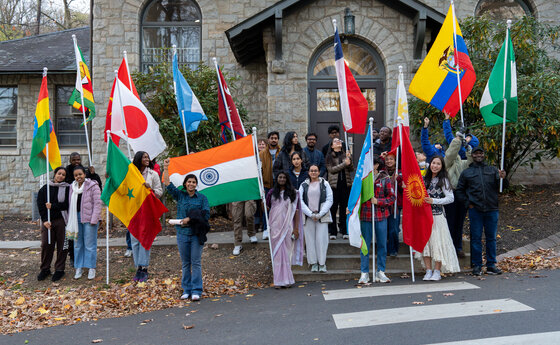 A group of students holding flags in front of a building