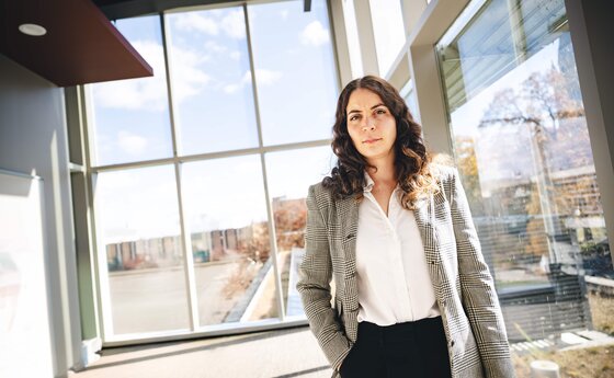 Sabrina Arias standing in a wide room with glass windows