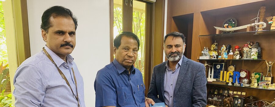 Three people standing together and posing with a document