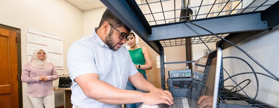 A young man working at a laptop in a laboratory