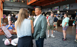 A man and woman speaking at a table at an expo