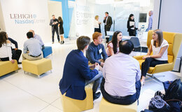 A group of people sitting around and talking in a well-lit lobby