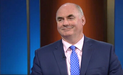 kevin cassidy in a dark blue suit with a light pink shirt